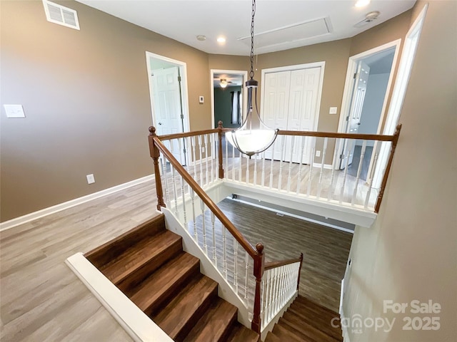 stairs featuring baseboards, visible vents, wood finished floors, and recessed lighting