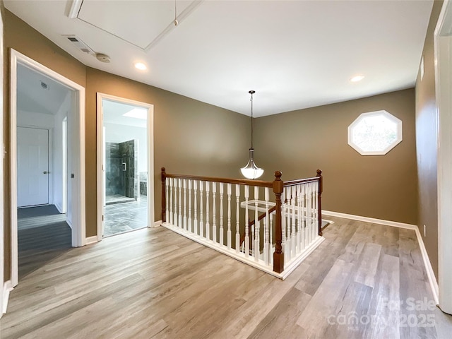 hallway with attic access, baseboards, an upstairs landing, light wood-type flooring, and recessed lighting