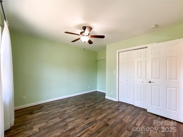 unfurnished bedroom with a ceiling fan, baseboards, dark wood finished floors, and a closet