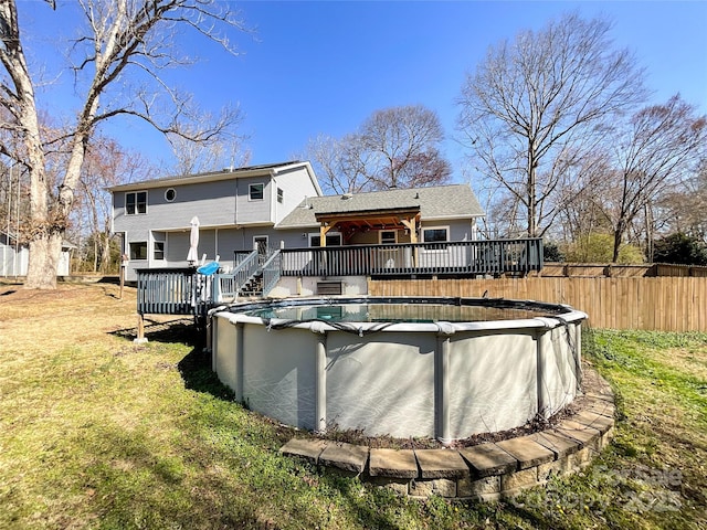 view of pool with a fenced in pool, a lawn, a wooden deck, and fence