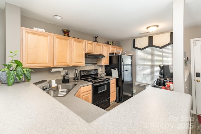 kitchen with a sink, black appliances, light brown cabinets, and under cabinet range hood