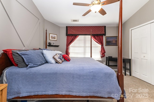 carpeted bedroom with a closet, visible vents, and a ceiling fan