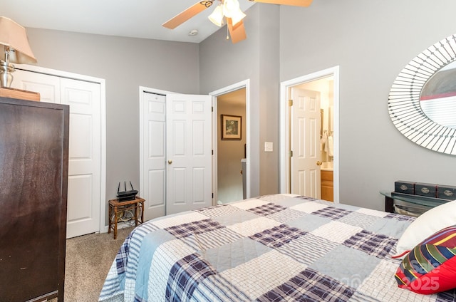 carpeted bedroom with multiple closets, lofted ceiling, and ceiling fan