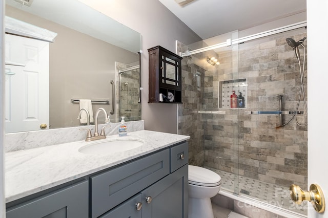 bathroom featuring a stall shower, vanity, and toilet