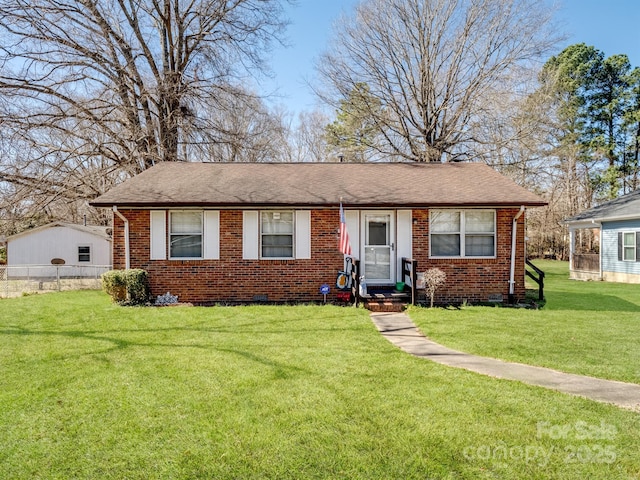 view of front of home with entry steps, brick siding, a front lawn, and a shingled roof