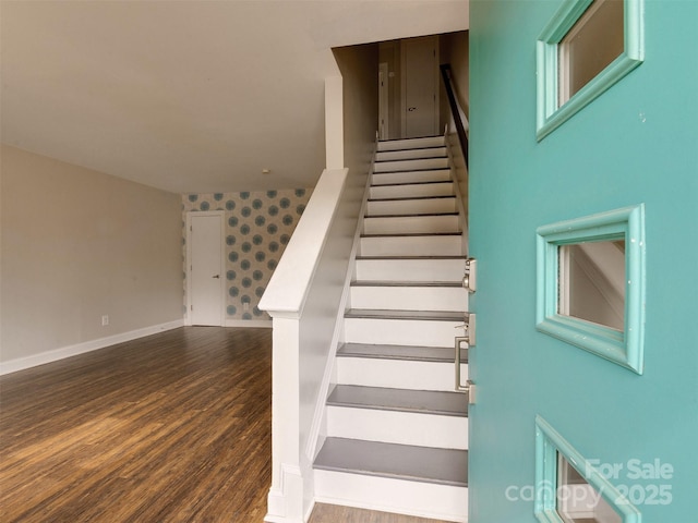 stairs with wallpapered walls, baseboards, and wood finished floors