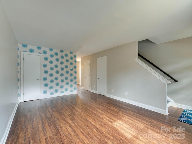 unfurnished living room featuring baseboards and wood finished floors