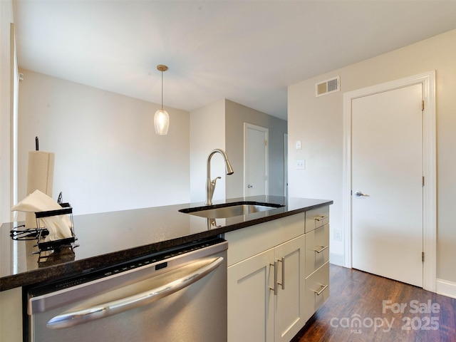 kitchen featuring a sink, visible vents, dishwasher, dark wood finished floors, and decorative light fixtures