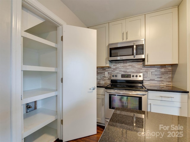 kitchen with dark stone counters, appliances with stainless steel finishes, and decorative backsplash