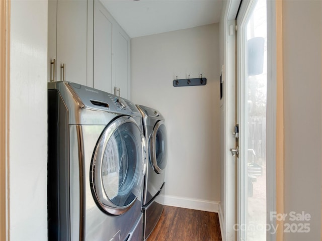 clothes washing area featuring dark wood-style floors, baseboards, cabinet space, and washer and dryer