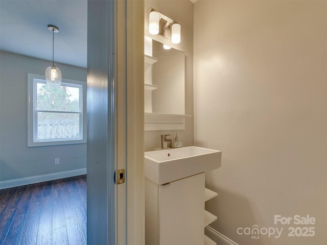 bathroom with vanity, baseboards, and wood finished floors