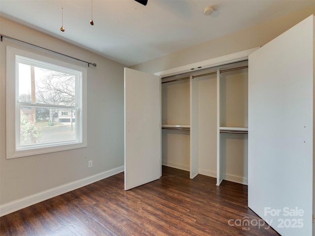 unfurnished bedroom with dark wood-style floors and baseboards