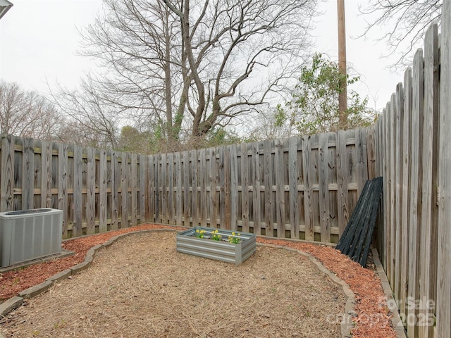 view of yard with central AC and a fenced backyard