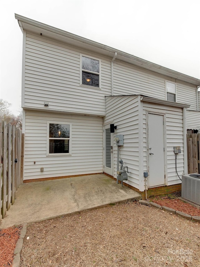 back of property with central AC, a patio, and fence