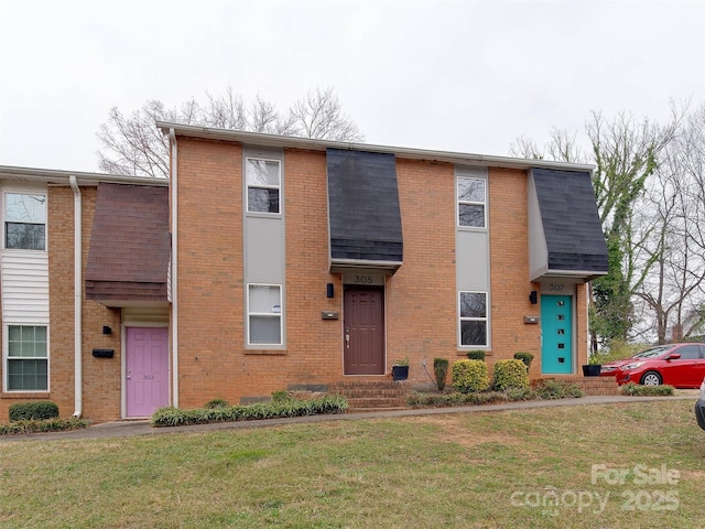 multi unit property with a front lawn, a shingled roof, and brick siding