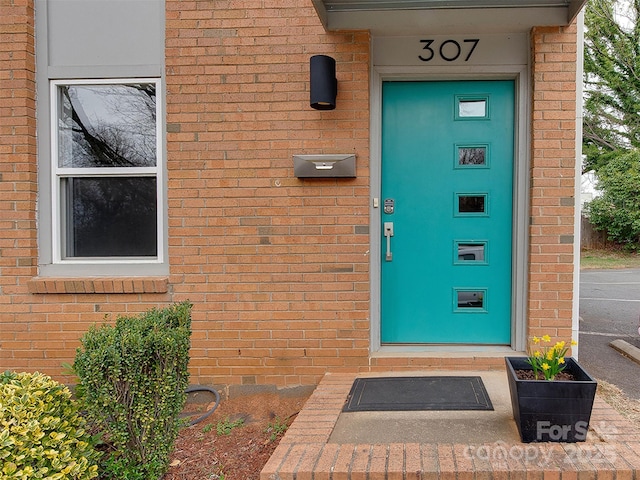 doorway to property featuring brick siding