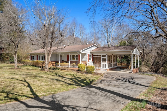 ranch-style house with aphalt driveway, a sunroom, a porch, and a front lawn