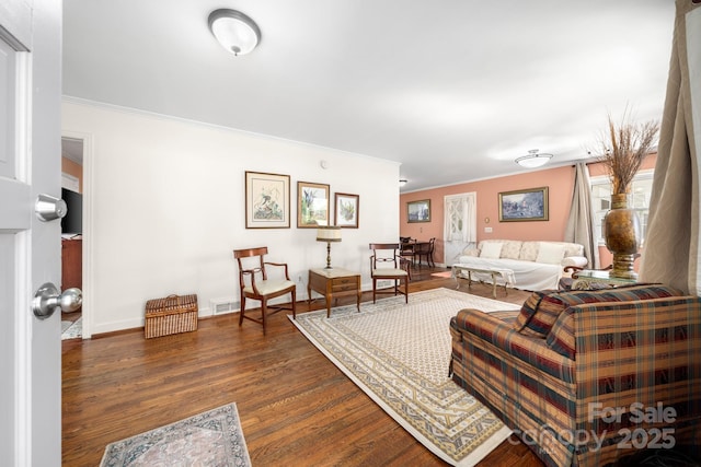 living area with baseboards, visible vents, ornamental molding, and dark wood-style flooring