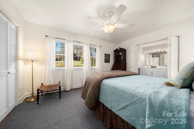 bedroom with a ceiling fan, carpet, baseboards, and ensuite bath