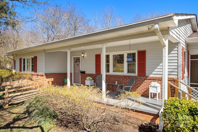 view of front of house featuring a porch and brick siding