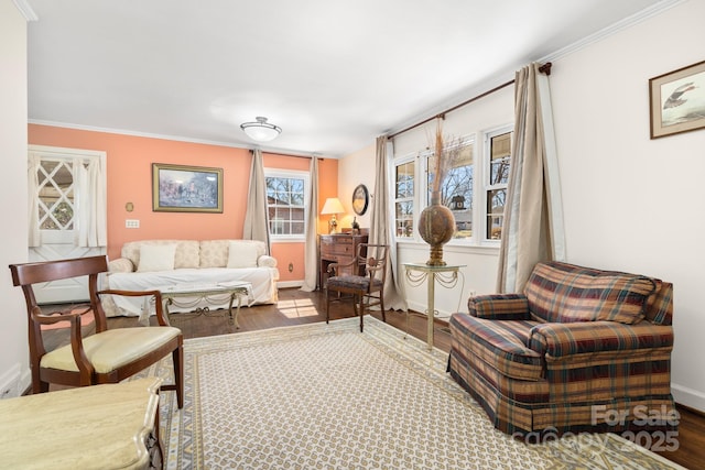 living room featuring wood finished floors, baseboards, and crown molding