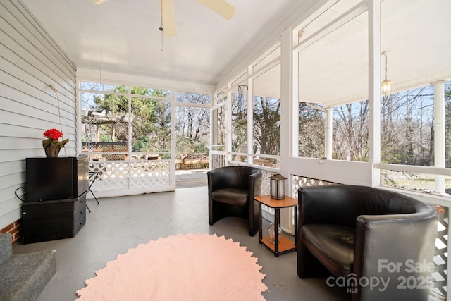 sunroom / solarium featuring healthy amount of natural light and ceiling fan