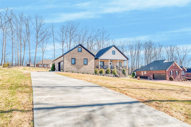 view of front of home featuring a porch, a garage, brick siding, and a front lawn