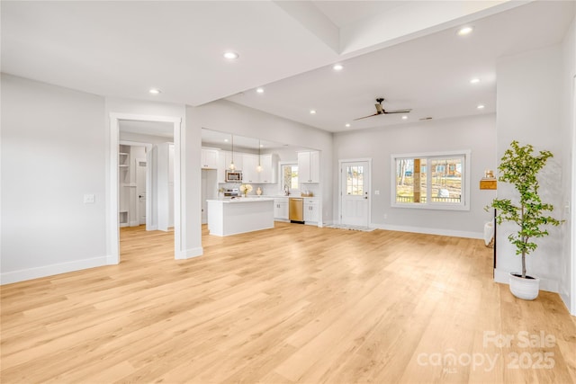 unfurnished living room featuring light wood-style floors, baseboards, a ceiling fan, and recessed lighting