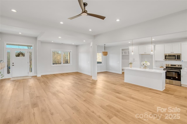 unfurnished living room with light wood-style flooring, baseboards, ceiling fan, and recessed lighting