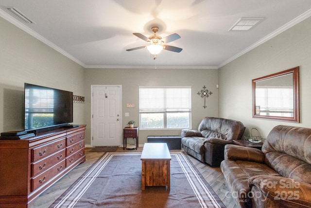 living area with ornamental molding, visible vents, and wood finished floors