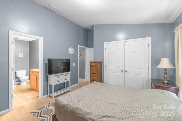 bedroom featuring a closet, visible vents, light carpet, connected bathroom, and baseboards