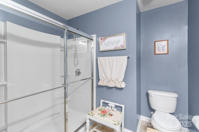 full bath featuring a stall shower, baseboards, and toilet