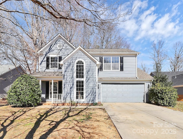 traditional home with a garage, concrete driveway, and a porch