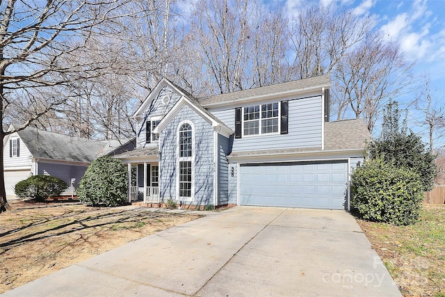 traditional-style home featuring a garage, roof with shingles, and driveway