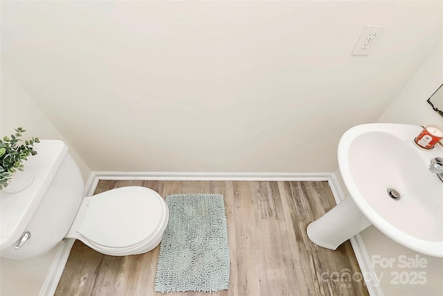 bathroom featuring wood finished floors, a sink, toilet, and baseboards