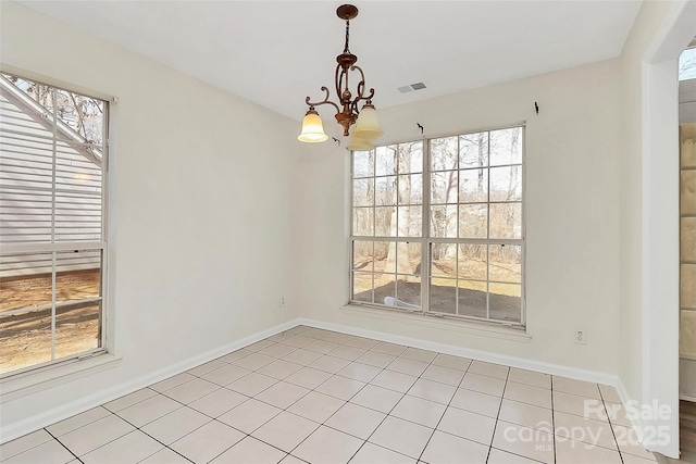 spare room with an inviting chandelier, baseboards, light tile patterned floors, and visible vents