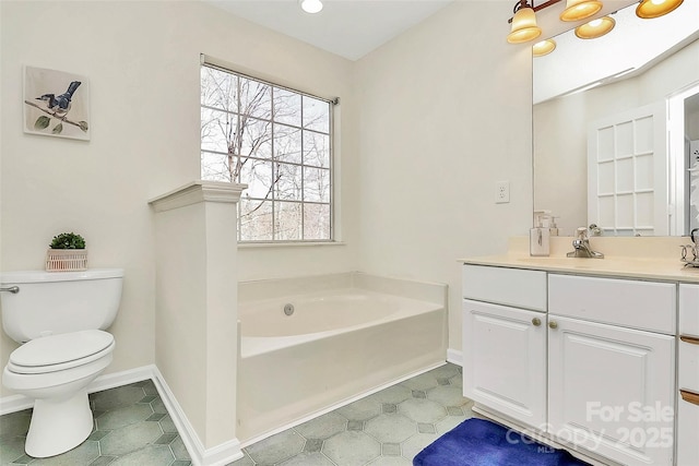 bathroom featuring baseboards, vanity, toilet, and a bath