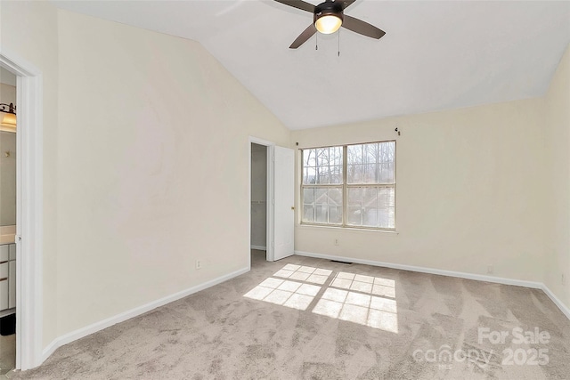 spare room featuring lofted ceiling, visible vents, baseboards, and light colored carpet