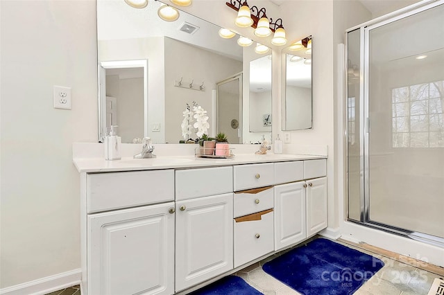 full bathroom with double vanity, a stall shower, visible vents, and a sink