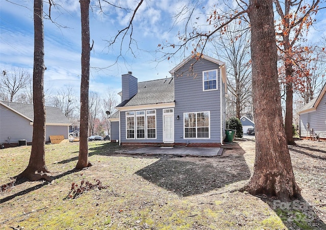 back of property featuring a chimney and a patio area