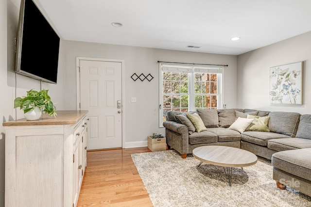 living area with light wood finished floors, recessed lighting, visible vents, and baseboards