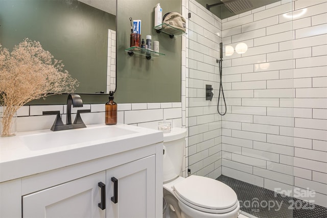 full bath featuring toilet, tile walls, tiled shower, and vanity