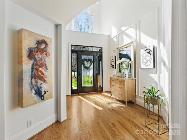 entrance foyer with a high ceiling, wood finished floors, and baseboards