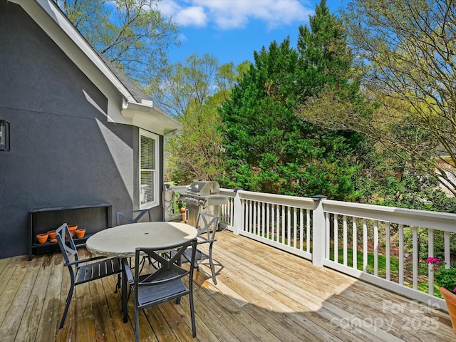deck featuring outdoor dining area and area for grilling