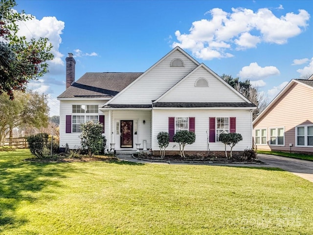 view of front of property with a chimney and a front lawn