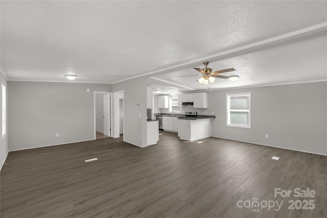 unfurnished living room with ceiling fan, ornamental molding, dark wood-style flooring, and a textured ceiling