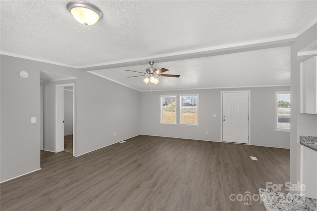 unfurnished living room with a textured ceiling, ornamental molding, and wood finished floors