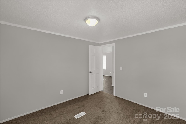 carpeted spare room with baseboards, crown molding, visible vents, and a textured ceiling