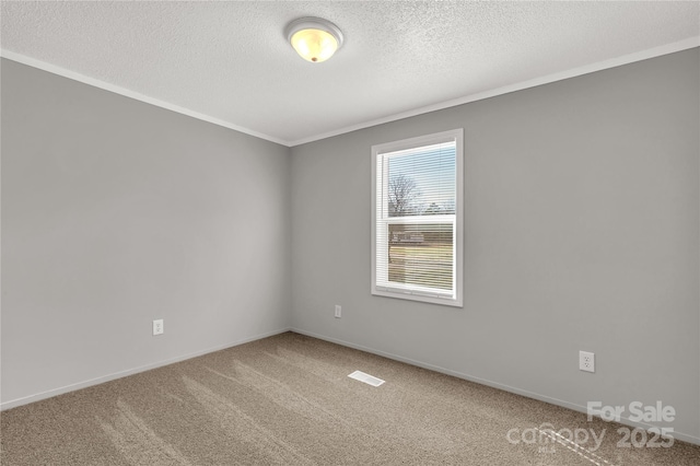 carpeted spare room featuring ornamental molding, visible vents, a textured ceiling, and baseboards