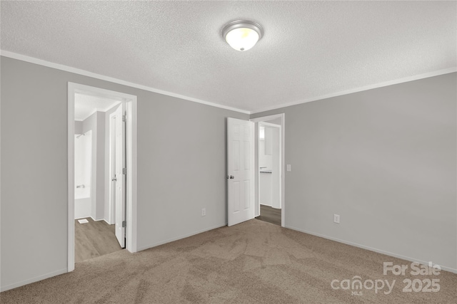 unfurnished bedroom with a textured ceiling, ornamental molding, and carpet flooring